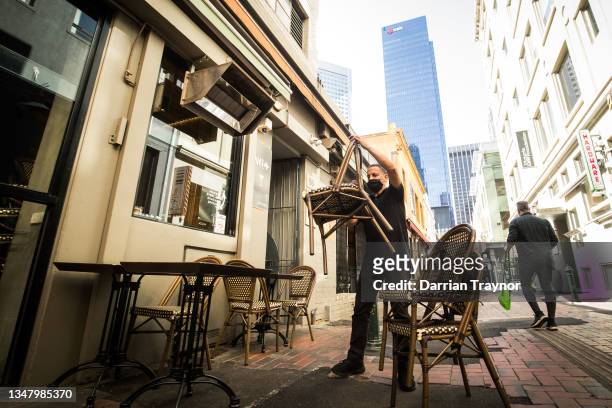 Cafe staff in Hardware lane prepare to re-open on October 22, 2021 in Melbourne, Australia. Lockdown restrictions have lifted in Melbourne after...