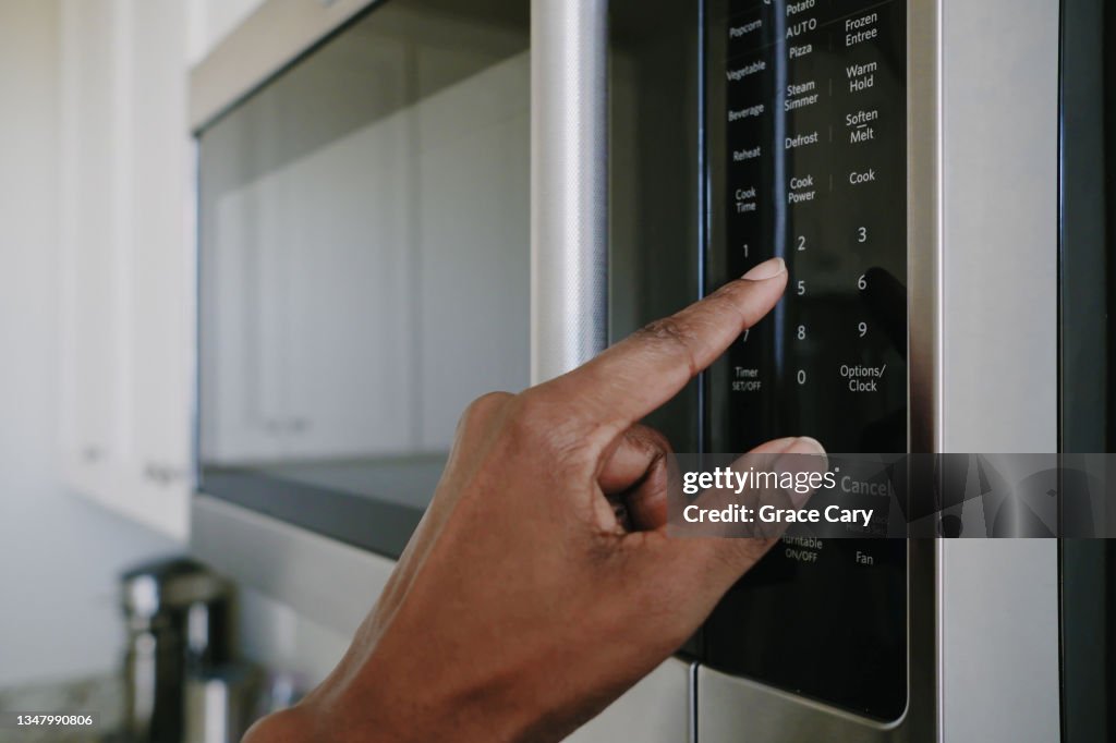 Woman Sets Cook Time on Microwave