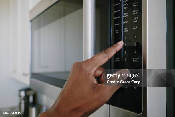 woman sets cook time on microwave - micro bildbanksfoton och bilder