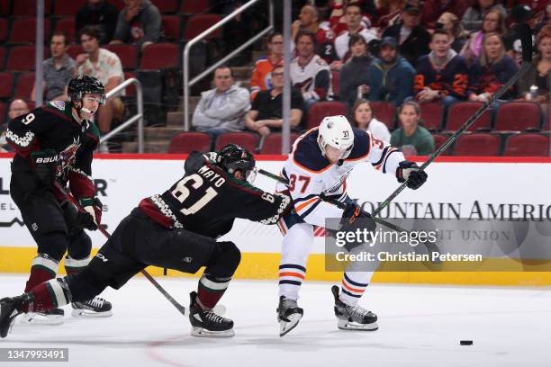 Warren Foegele of the Edmonton Oilers skates in with the puck to score a goal ahead of Dysin Mayo of the Arizona Coyotes during the first period of...