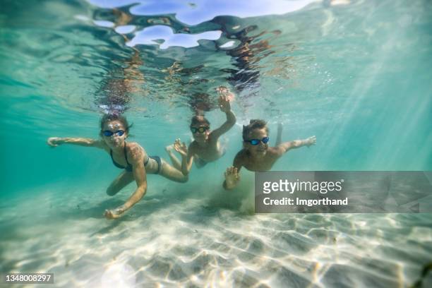 children enjoying swimming and playing in clean, shallow sea - undersea stock pictures, royalty-free photos & images