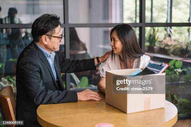 employee packing box at workplace on last working day - employee leaving stock pictures, royalty-free photos & images