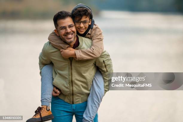 portrait of the father carrying the child on the shoulder - eyeglasses winter stock pictures, royalty-free photos & images