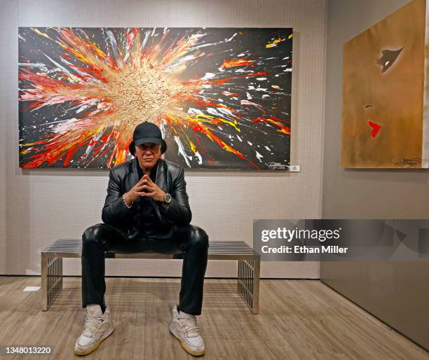 Kiss singer/bassist Gene Simmons poses in front of his acrylic on canvas work "The Birth" on display at the debut of Gene Simmons ArtWorks at...