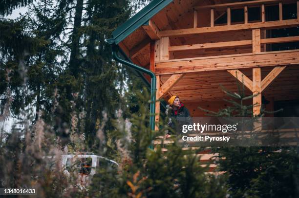 a man on vacation in a  mountain cabin - rustic cabin stock pictures, royalty-free photos & images