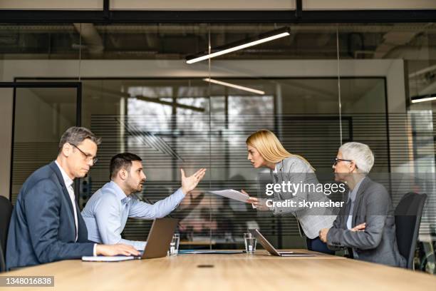 young couple arguing about paperwork on a meeting with their lawyers. - divorce lawyer stock pictures, royalty-free photos & images