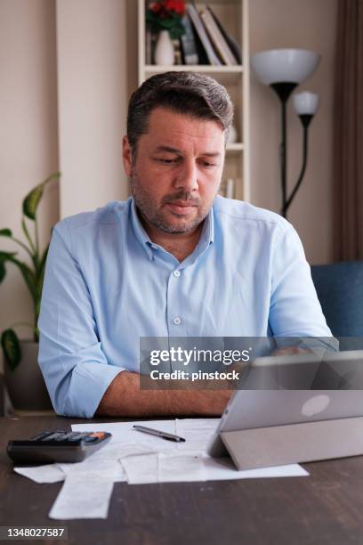 man calculating personal expenses at home - personal finance stock pictures, royalty-free photos & images