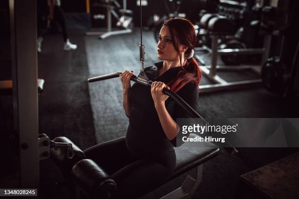 allenamento donna in forma sulla macchina per esercizi - sollevamento pesi femminile foto e immagini stock