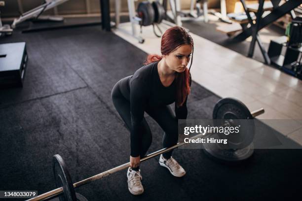 young woman exercising with weights - women's weightlifting stock pictures, royalty-free photos & images