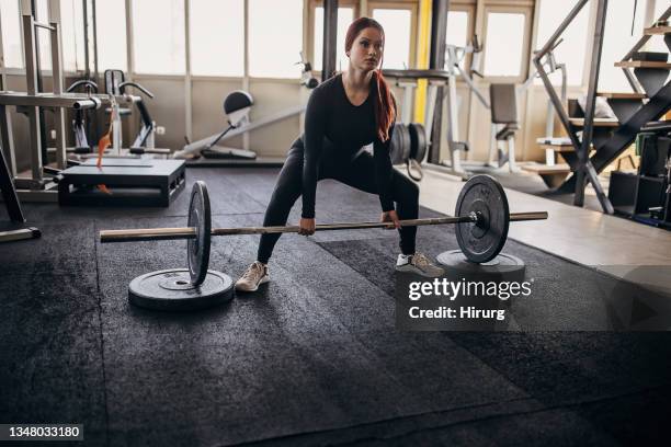 young woman exercising with weights - women's weightlifting stock pictures, royalty-free photos & images