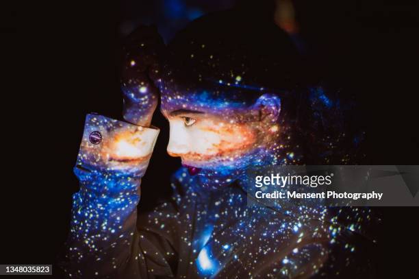 bizarre woman covered in colorful abstract patterns of space projected on his face - all shirts stock-fotos und bilder