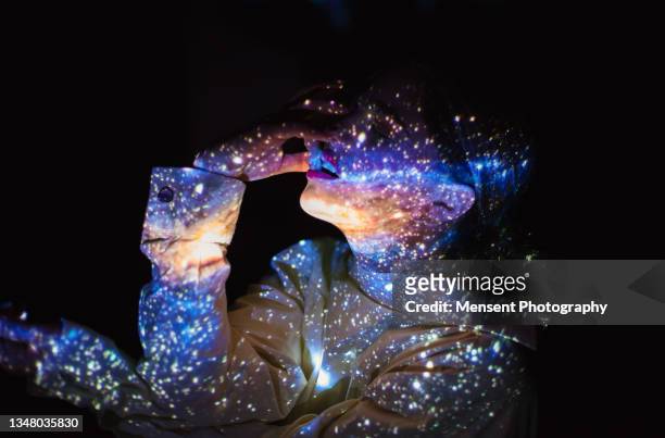 a woman covered in colorful abstract patterns of space projected on his face - hologram projection stock pictures, royalty-free photos & images