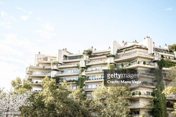 multifamily ecological homes with green terraces and the facade decorated with plants and trees. - sustainable design stockfoto's en -beelden