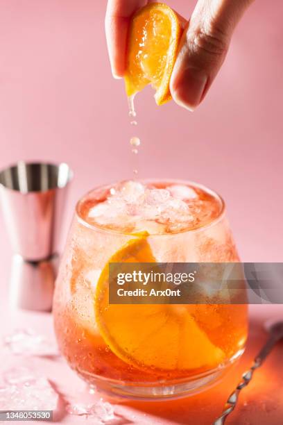 orange cocktail with ice and orange slice in glass - whiskey stock pictures, royalty-free photos & images