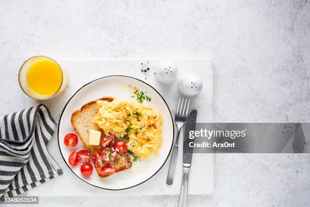 scrambled eggs with toast and orange juice - roerei stockfoto's en -beelden