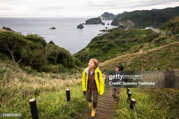 a couple enjoying a hike on a cape they visited on vacation. - asian tourist bildbanksfoton och bilder