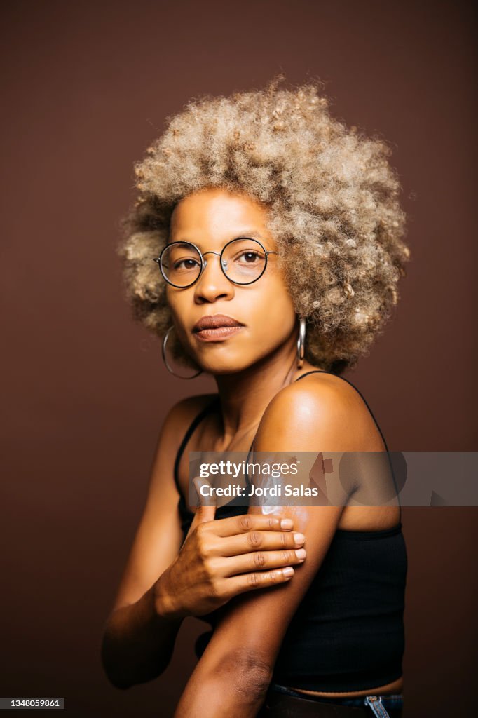 Woman applying skin care cream on her arm
