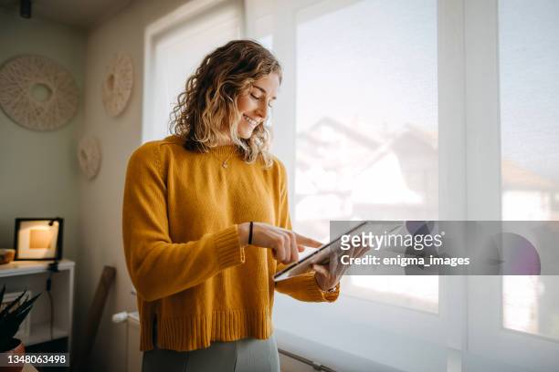 businesswoman using a digital tablet while working from home - woman ipad stockfoto's en -beelden
