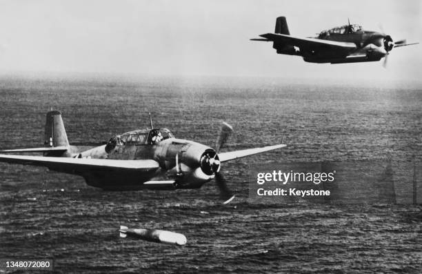 United States Navy Grumman TBF-1 Avenger carrier-based torpedo bomber flying in formation drop a Mark XIII practice torpedo during a low level...