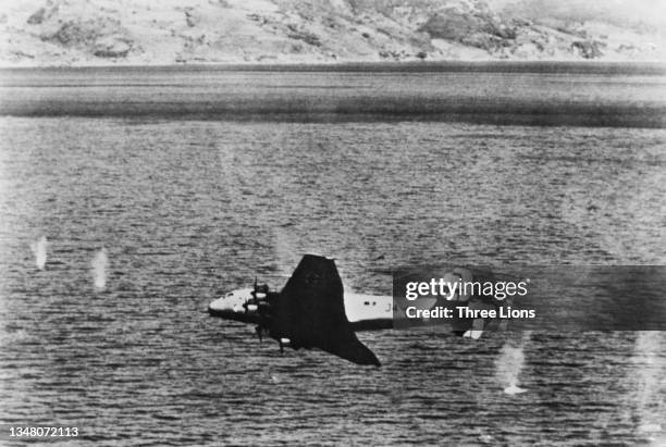 Cannon shells splash in the water as a German Luftwaffe Junkers Ju 90 J4+KH "Thuringen" four-engined transport aircraft of Lufttransportstaffel 290...