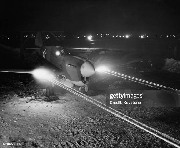 The wing mounted synchronised Browning machine guns of a United States Army Air Force Curtiss Hawk P-40E Kittyhawk fighter aircraft fires tracer...