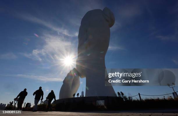 People walk past "Water's Soul", a sculpture by artist Jaume Plensa after the pier it is located on opened to the public on October 22, 2021 in...