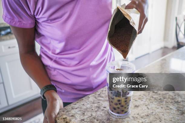 woman makes blueberry banana smoothie - flax seed stock pictures, royalty-free photos & images