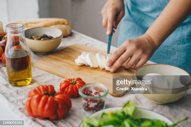 donna che cucina insalata caprese - taglio foto e immagini stock