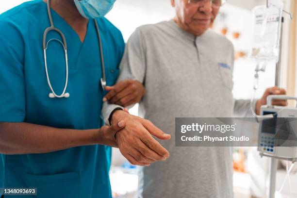 health visitor and a  man during home visit - arm in arm stockfoto's en -beelden