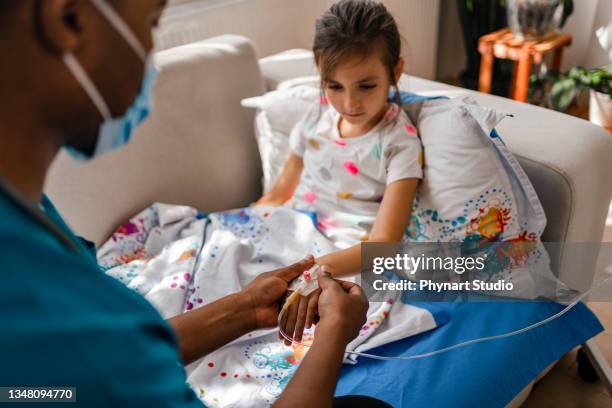 male nurse attaching iv drip on patient - hospital mask stock pictures, royalty-free photos & images