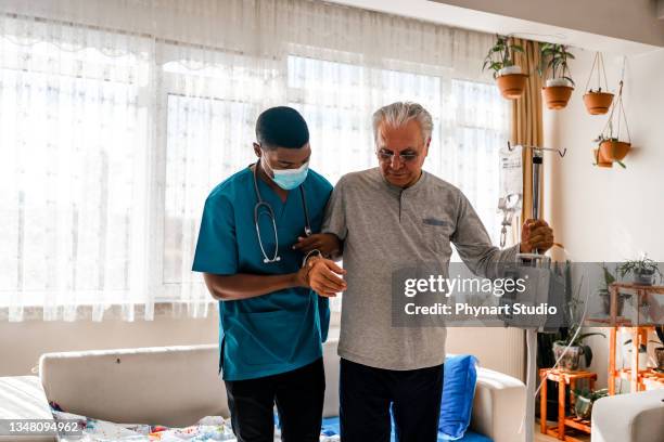 gesundheitsbesucher und ein mann beim hausbesuch - iv infusion stock-fotos und bilder