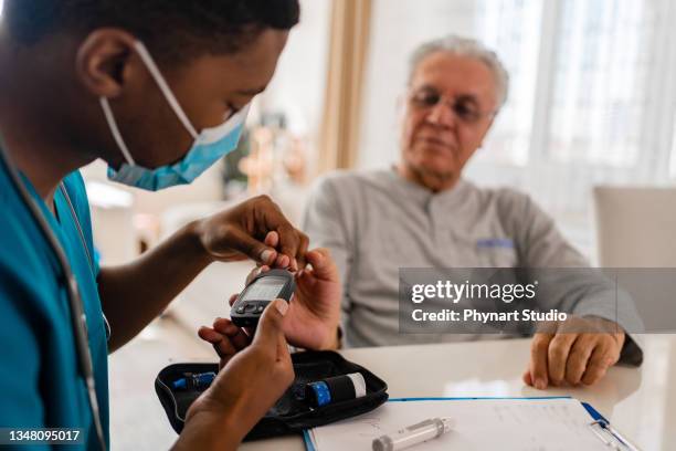 bezirkskrankenschwester bei hausbesuch - nurse with old male patient home care stock-fotos und bilder