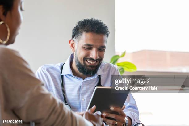 doctor looking at digital tablet - plastic surgeon stock pictures, royalty-free photos & images