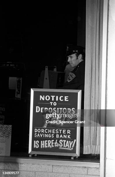 Determined bank sign and guard at Columbia Point, Dorchester, Boston, Massachusetts, 1970.