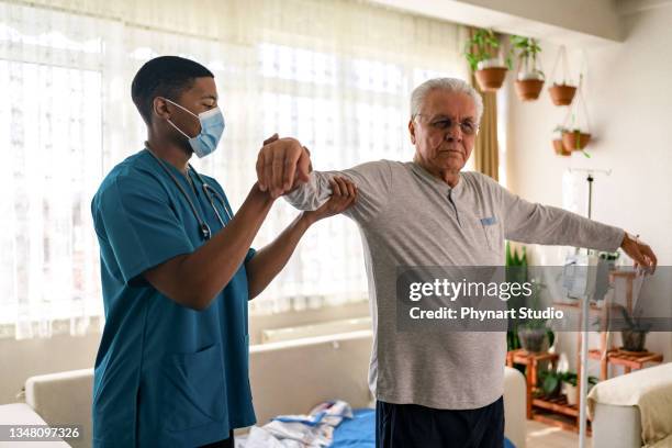 old man training with physiotherapist - man touching shoulder stock pictures, royalty-free photos & images