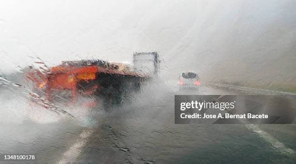 car point of view driving, truck passing on a wet highway with lots of rain. - foggy road stock pictures, royalty-free photos & images