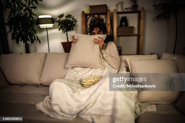 watching a scary movie at night - woman watching horror movie stock pictures, royalty-free photos & images