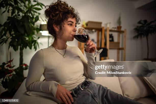 woman relaxing at night on a sofa - woman enjoying night stockfoto's en -beelden