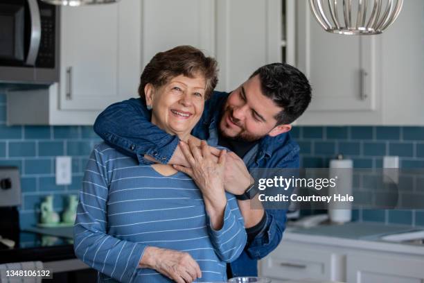 adult child hugging mother - old brother stock pictures, royalty-free photos & images