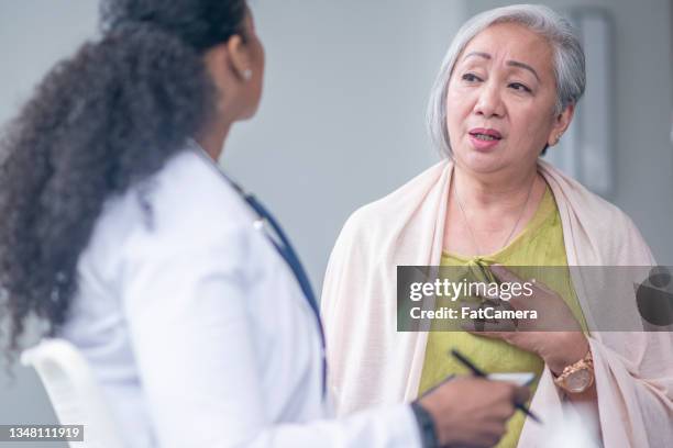 senior patient complaining of chest pain - chest pain stock pictures, royalty-free photos & images