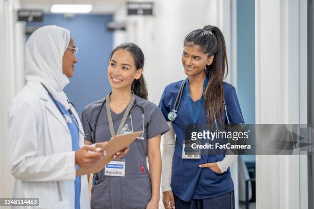 muslim doctor informing her nursing staff - arabic doctor stockfoto's en -beelden