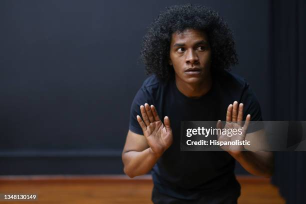 african american drama student improvising in an acting class - acteren stockfoto's en -beelden