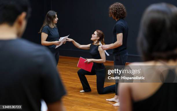 acting coach directing an improv exercise with her students in a drama class - uitvoerende kunst voorstelling stockfoto's en -beelden