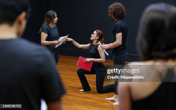 acting coach directing an improv exercise with her students in a drama class - acteren stockfoto's en -beelden