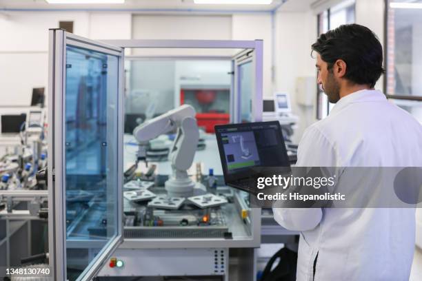 profesor en una clase de stem en el laboratorio desarrollando un brazo robótico - robótica fotografías e imágenes de stock