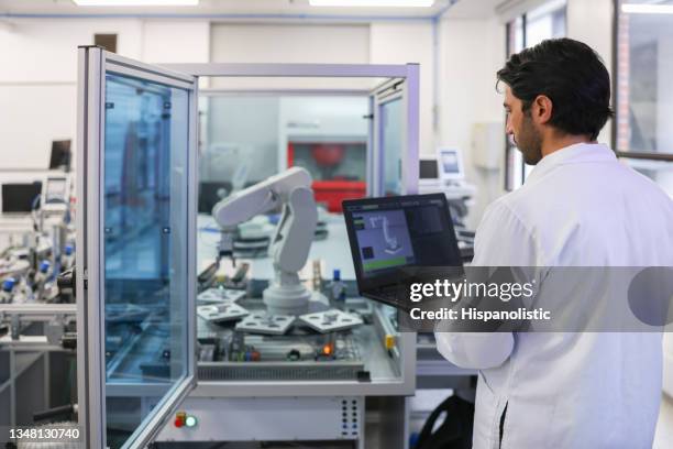 teacher in a stem class at the lab developing a robotic arm - industrial robotics stock pictures, royalty-free photos & images