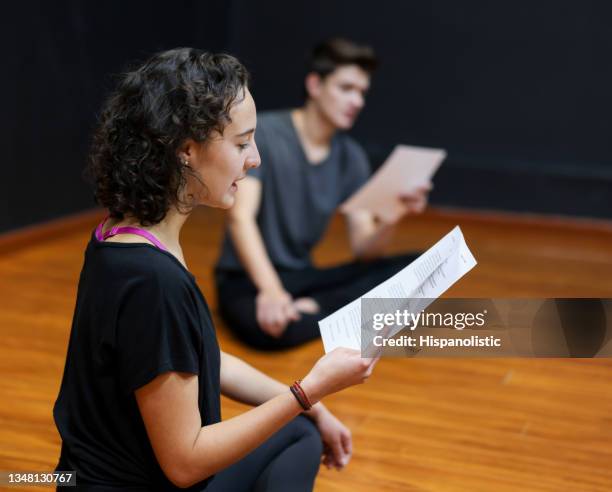 des étudiants en art dramatique lisant un scénario dans un cours de théâtre - actor photos et images de collection