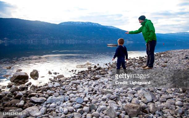 skipping stones with dad - kelowna stock pictures, royalty-free photos & images