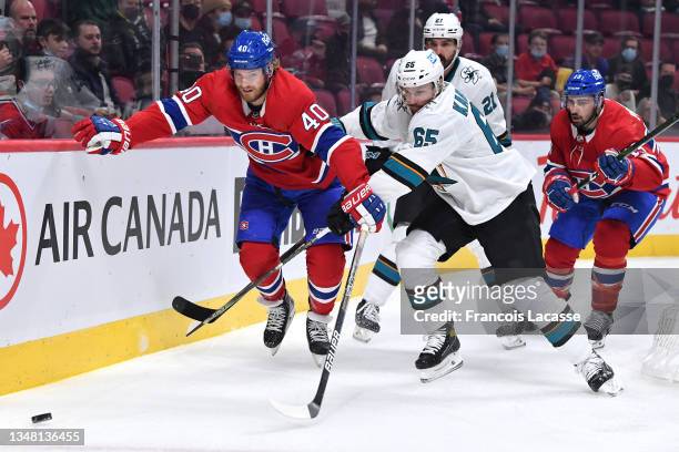 Joel Armia of the Montreal Canadiens and Erik Karlsson of the San Jose Sharks fight for the puck in the NHL game at the Bell Centre on October 19,...