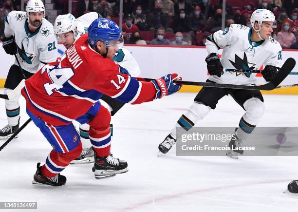 Nick Suzuki of the Montreal Canadiens passes the puck against the San Jose Sharks in the NHL game at the Bell Centre on October 19, 2021 in Montreal,...